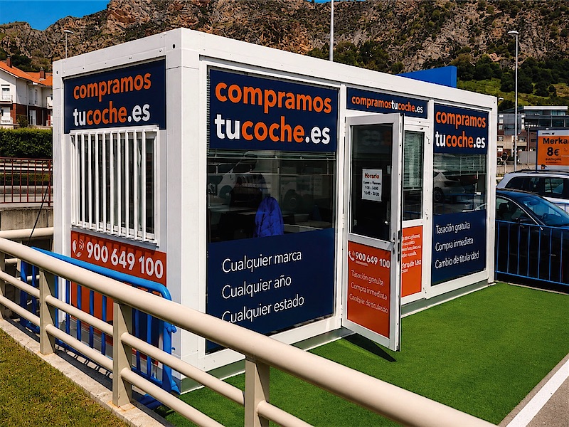 Caseta modular de un punto de venta de coches vinilada por fuera con la marca y el teléfono.