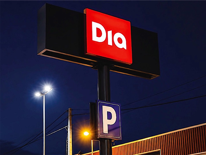 Monoposte luminoso de un supermercado con el rótulo de aparcamiento, de noche.