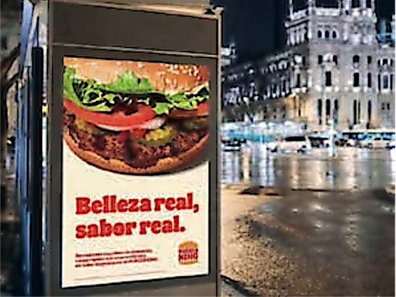 Mupi publicitario en la calle con la gráfica de una campaña.
