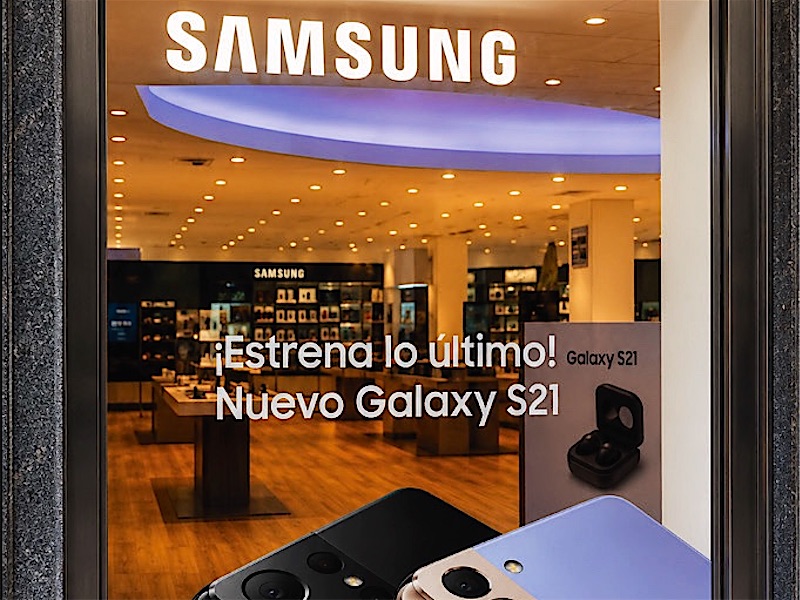 Escaparate de una tienda de telefonía con la gráfica del lanzamiento de un nuevo móvil.